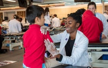 Alt text: image of student doctor performing an exam on a young boy